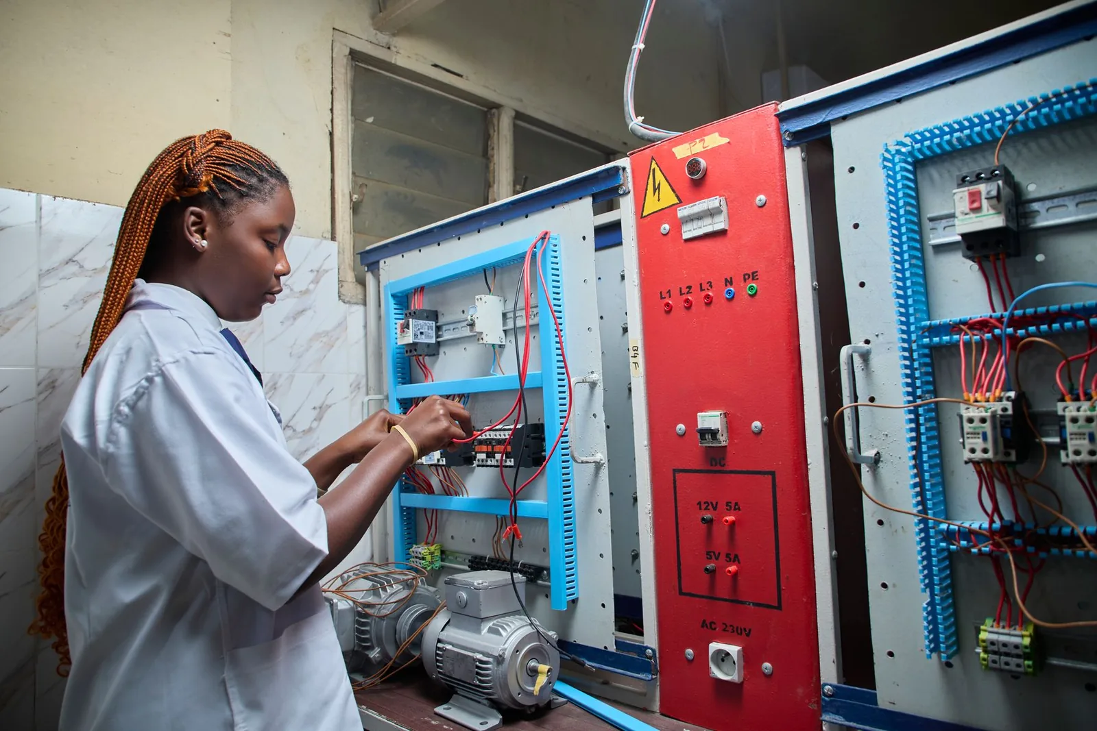Technicienne contrôlant une installation électrique.